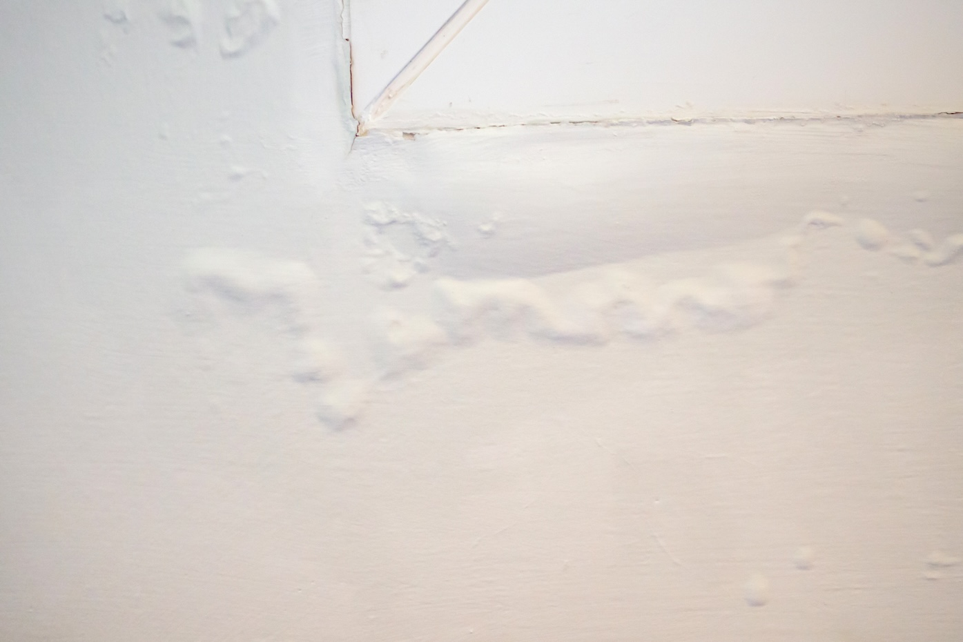 house wall near the window with some water stain show peeling paint